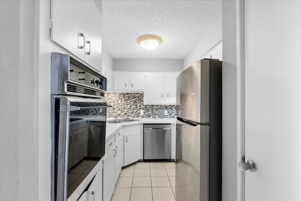a kitchen with stainless steel appliances a refrigerator sink and stove