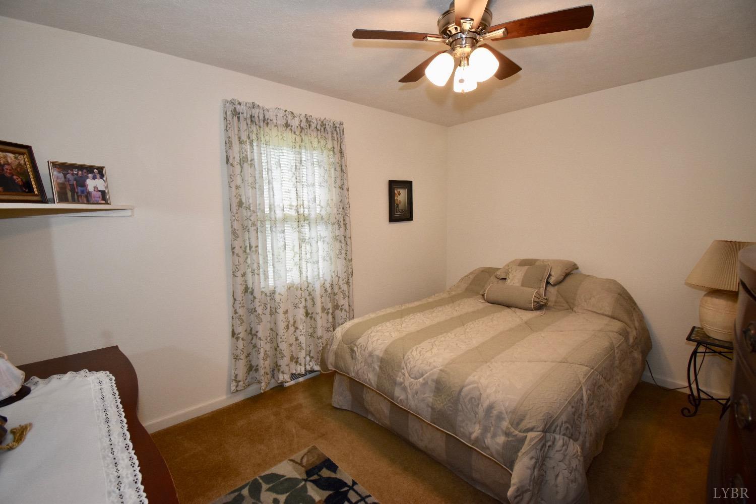 104 River Ridge Road Madison Heights, VA 24572 - Photo 18 of 35 a bedroom with a bed and a chandelier