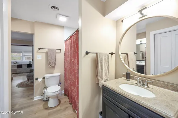 a bathroom with a granite countertop toilet sink and mirror