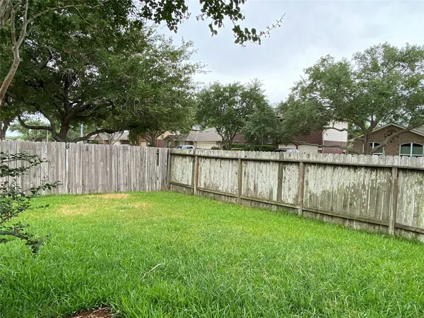 a view of a backyard with a small yard and large trees