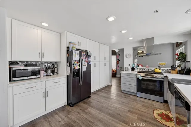 a kitchen with stainless steel appliances a stove a refrigerator a sink a stove and cabinets