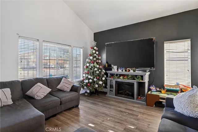 a living room with furniture a flat screen tv and a fireplace
