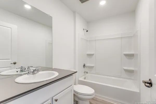 a bathroom with a sink a toilet and a mirror