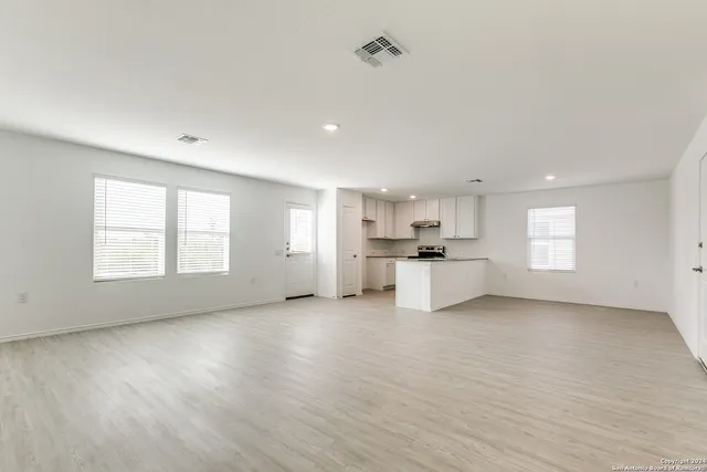 a view of a kitchen with a sink and dishwasher a refrigerator with wooden floor