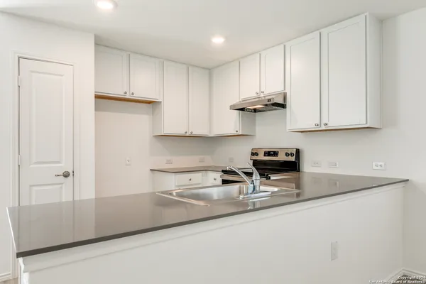 a kitchen with stainless steel appliances granite countertop a sink and a white cabinets