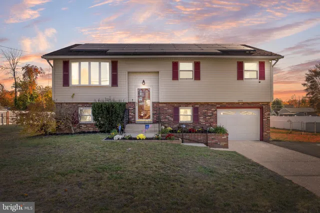 a front view of a house with a garden and yard