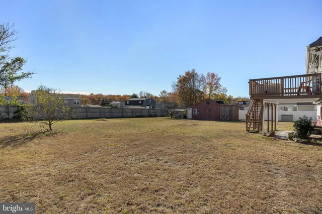 a view of a yard with wooden fence