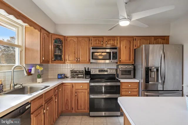 a kitchen with a sink a counter top space stainless steel appliances and cabinets