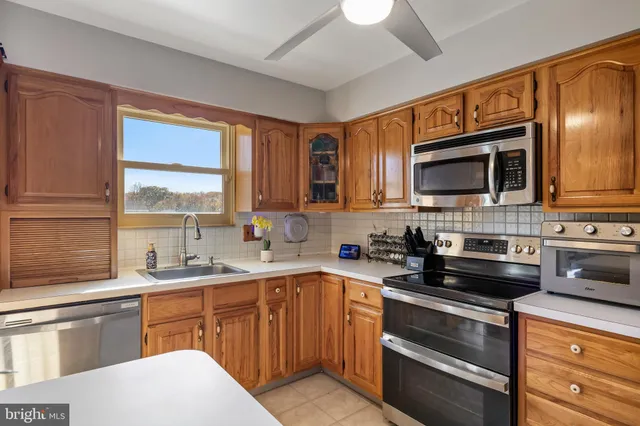 a kitchen with stainless steel appliances a stove sink microwave and cabinets