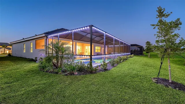 a dining room with furniture large windows and wooden floor