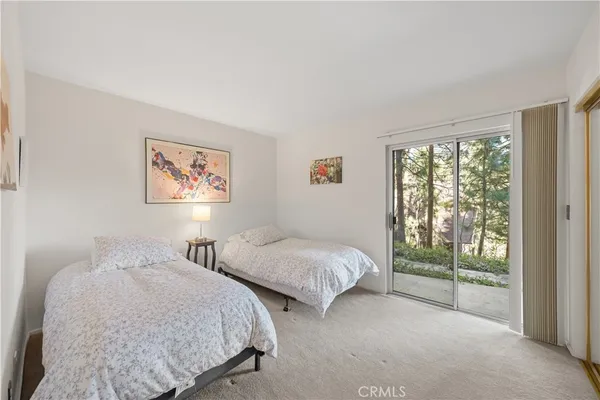 a spacious bedroom with two beds and a wall painting