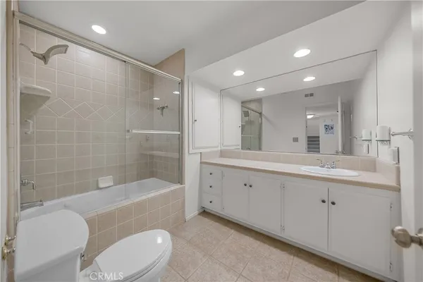 a bathroom with a bathtub shower sink mirror and toilet