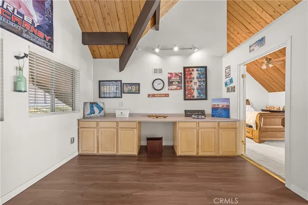 a kitchen with stainless steel appliances granite countertop a refrigerator a oven and white cabinets with wooden floor