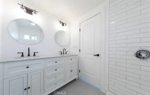 a bathroom with a double vanity sink and mirror