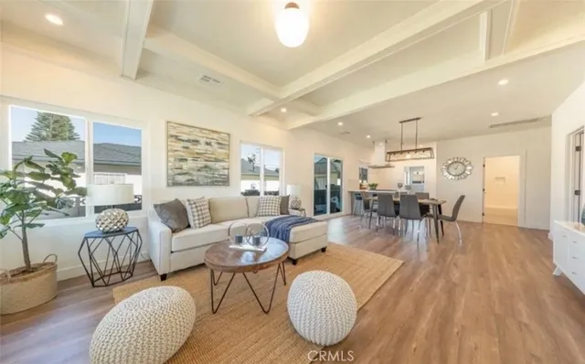a living room with furniture dining table a chandelier and a potted plant