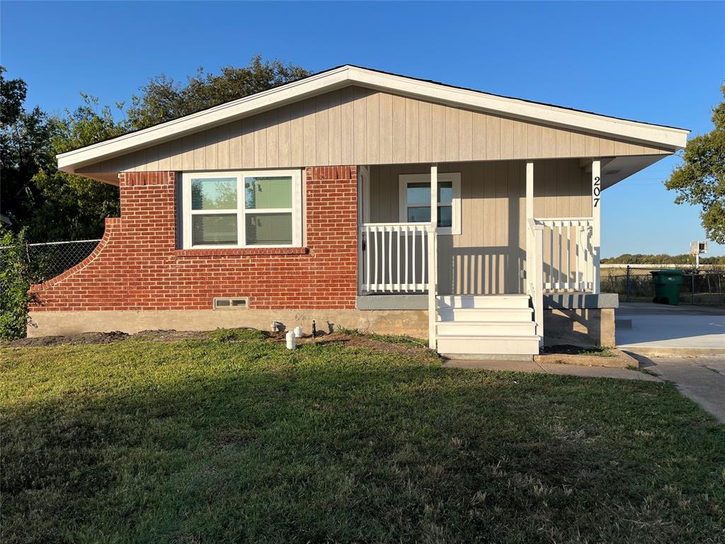 207 Wilmer Heights Drive Wilmer, TX 75172 - Photo 1 of 22 a front view of a house with a garden