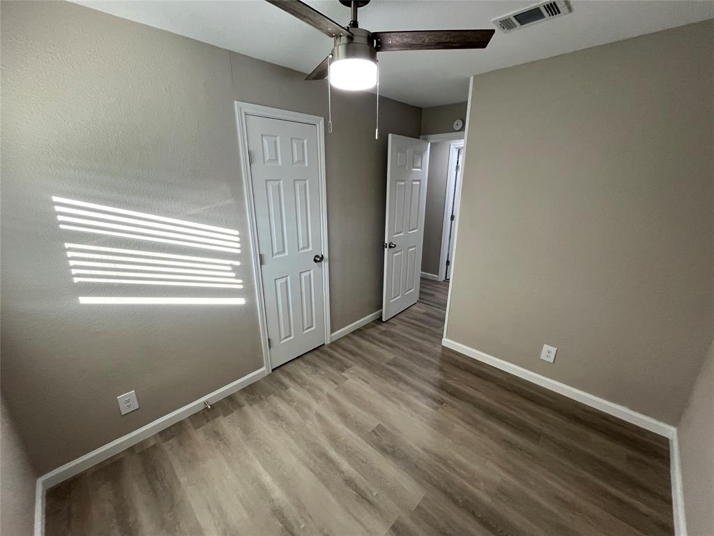 207 Wilmer Heights Drive Wilmer, TX 75172 - Photo 16 of 22 an empty room with wooden floor and windows