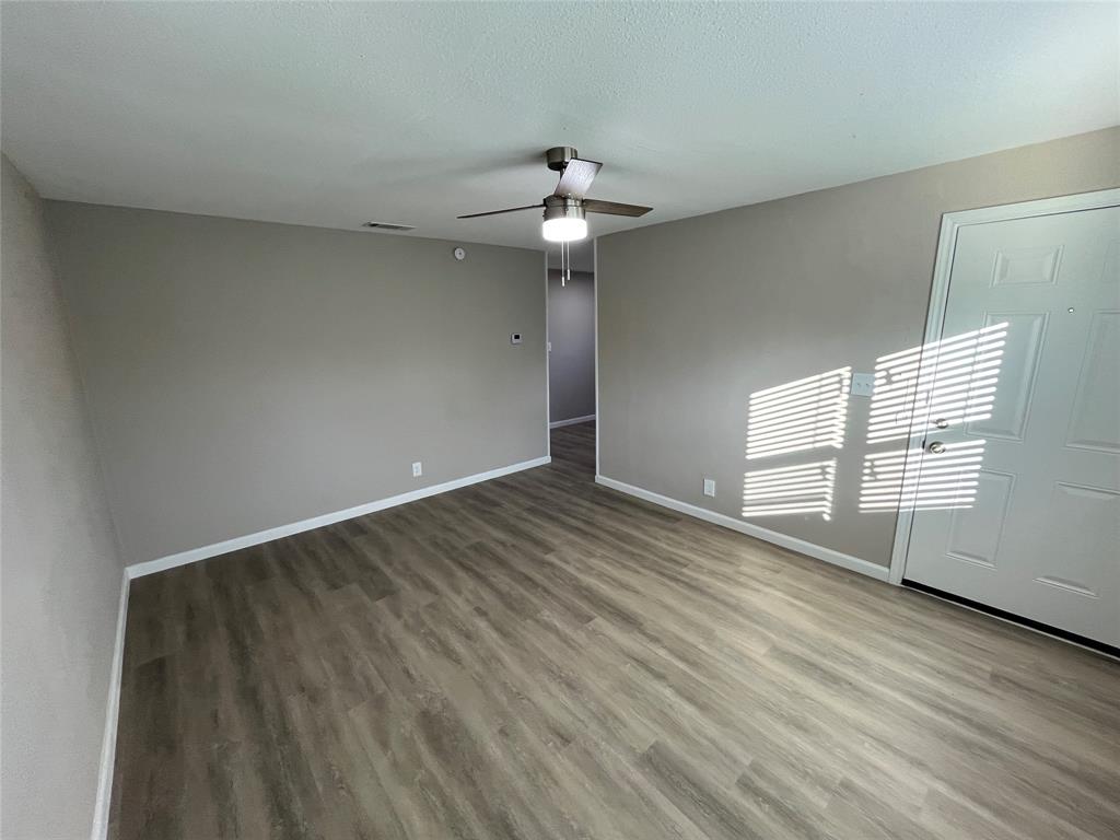 207 Wilmer Heights Drive Wilmer, TX 75172 - Photo 4 of 22 wooden floor in an empty room with a window