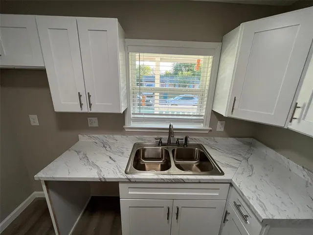 a kitchen that has a sink cabinets and window