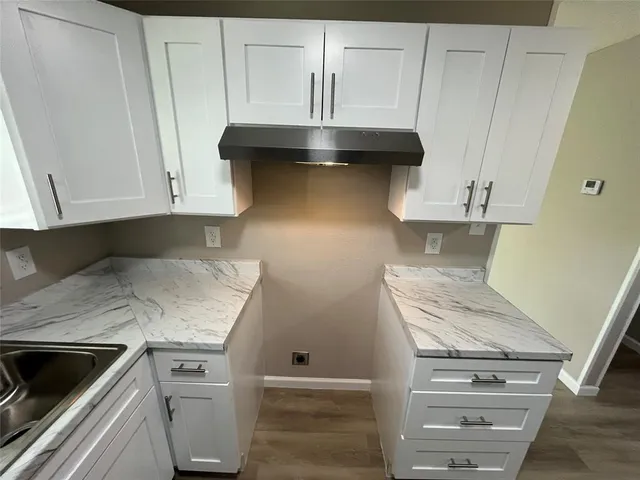 a kitchen with granite countertop a sink and a stove