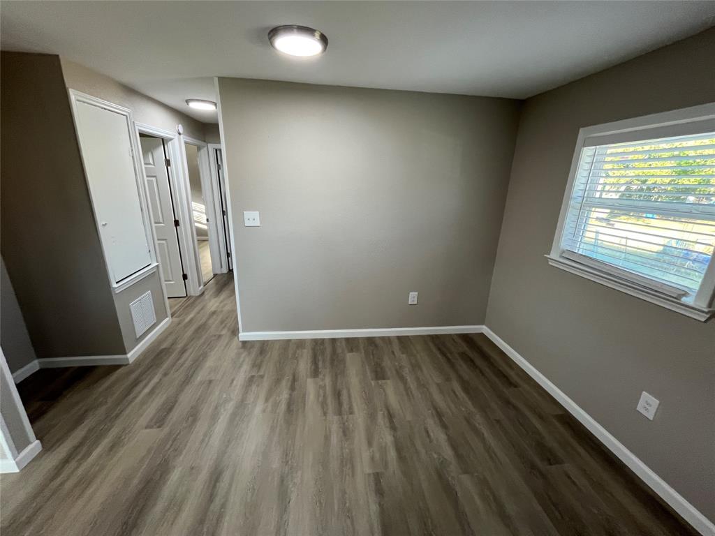 207 Wilmer Heights Drive Wilmer, TX 75172 - Photo 9 of 22 an empty room with wooden floor and windows