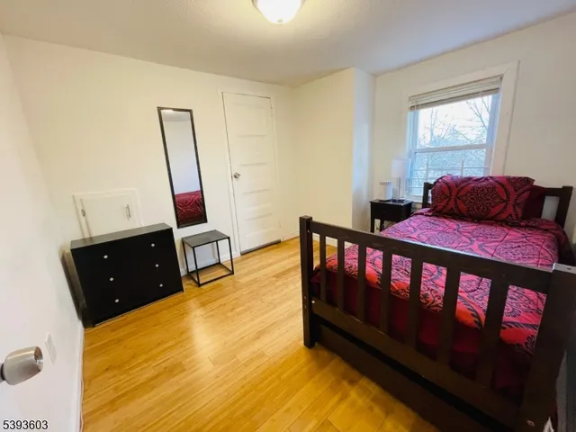 a bedroom with two beds and wooden floor