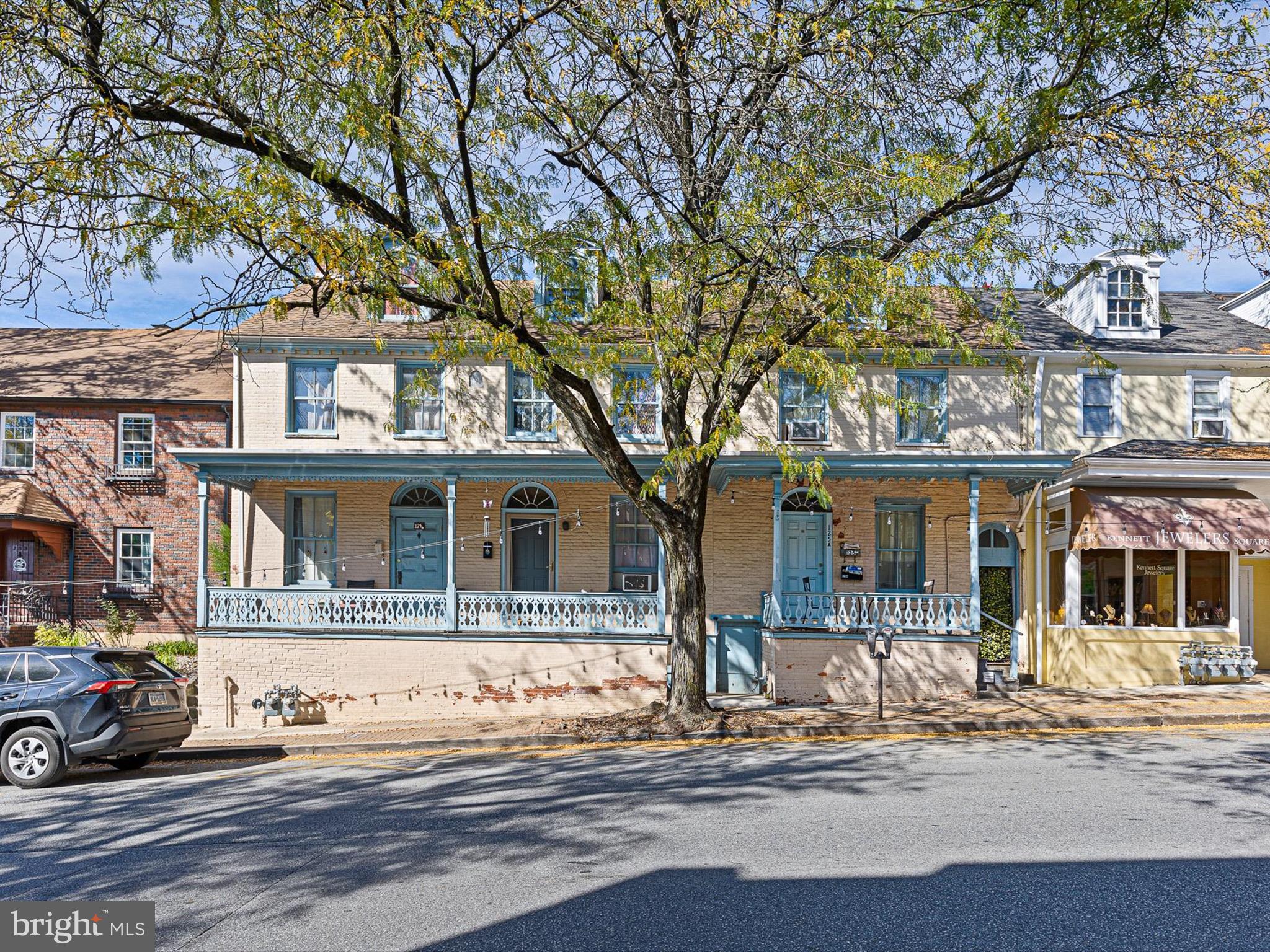 a front view of a house with a tree