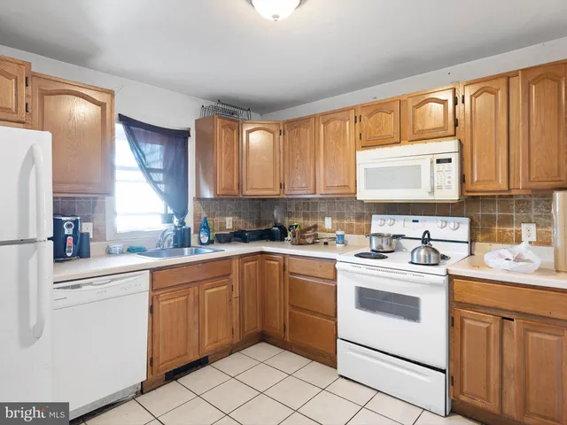 a kitchen with cabinets appliances a sink and a window