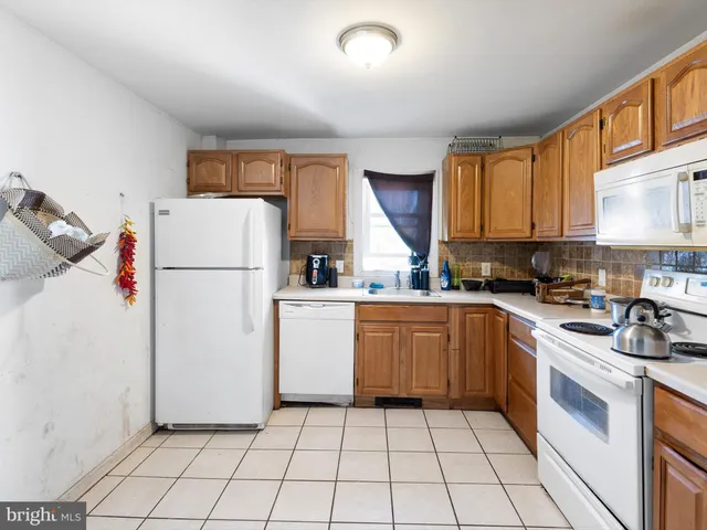 a kitchen with a refrigerator a stove top oven and cabinets