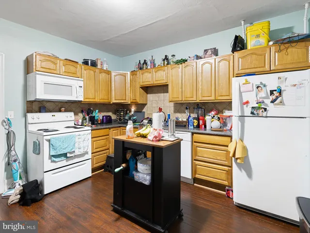 a view of kitchen with wooden floor and electronic appliances