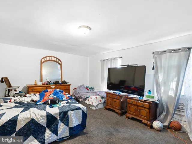 a bedroom with furniture and a flat screen tv