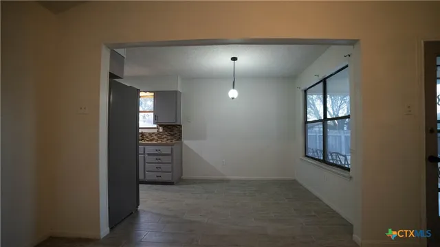 an empty room with windows and cabinet