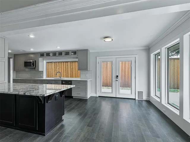 a kitchen with granite countertop a stove and wooden floor