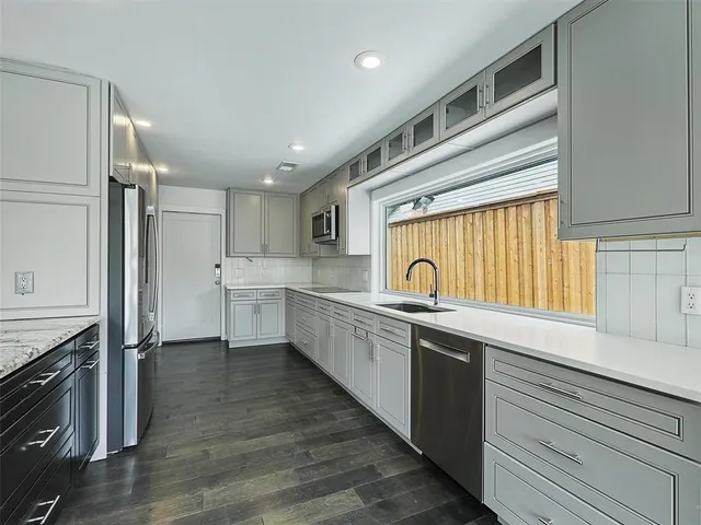 a kitchen with stainless steel appliances granite countertop a sink a stove and a refrigerator