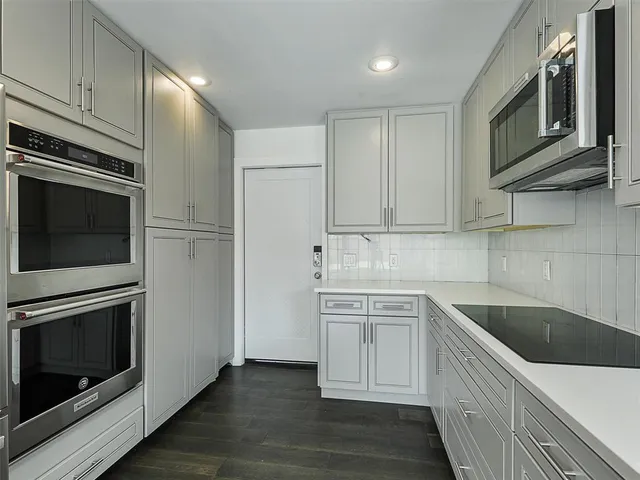 a kitchen with white cabinets stainless steel appliances and sink