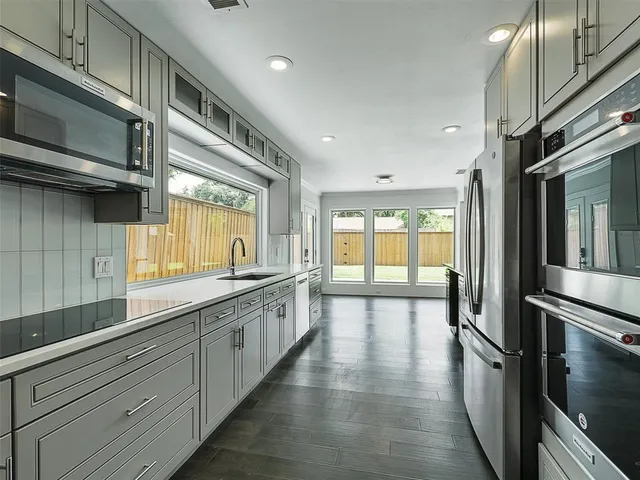 a large kitchen with a large window and stainless steel appliances