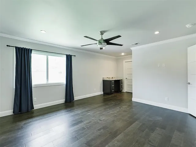 an empty room with windows and ceiling fan