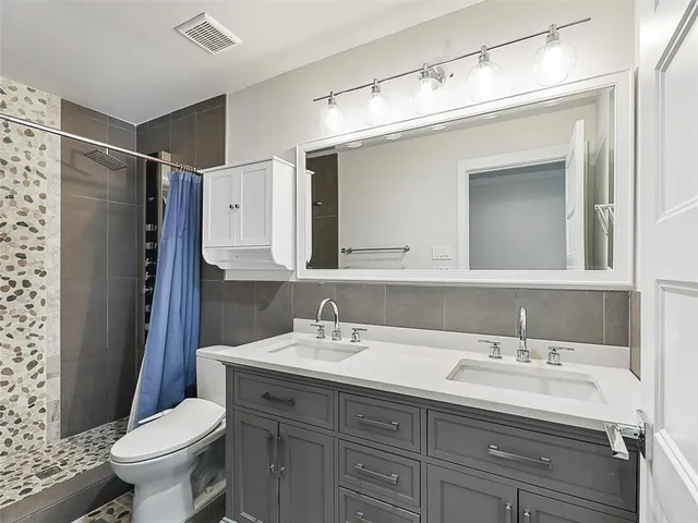 a bathroom with a sink toilet and mirror