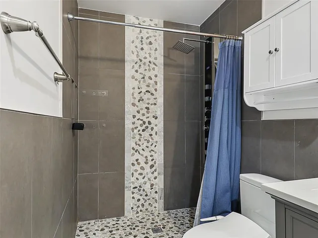 a bathroom with a shower toilet and sink