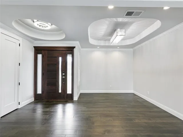 an empty room with wooden floor and cabinet