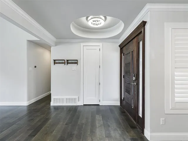 an empty room with wooden floor closet and windows