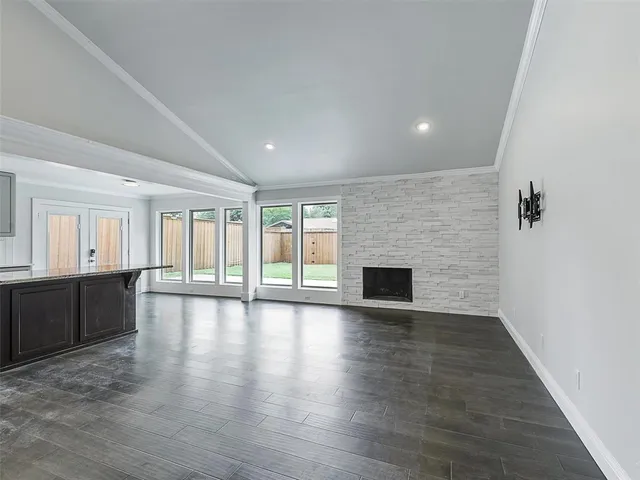 an empty room with wooden floor and fireplace