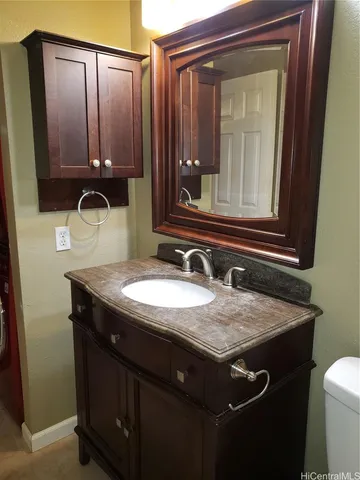 a bathroom with a granite countertop sink and a mirror