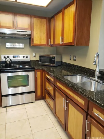 a kitchen with stainless steel appliances granite countertop a stove a sink and a microwave