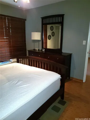 a bedroom with a bed and a mirror on dresser