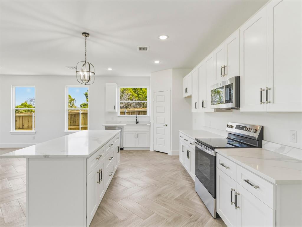 1412 Ridgeview Circle Granbury, TX 76048 - Photo 3 of 20 a large kitchen with stainless steel appliances granite countertop a stove and a sink
