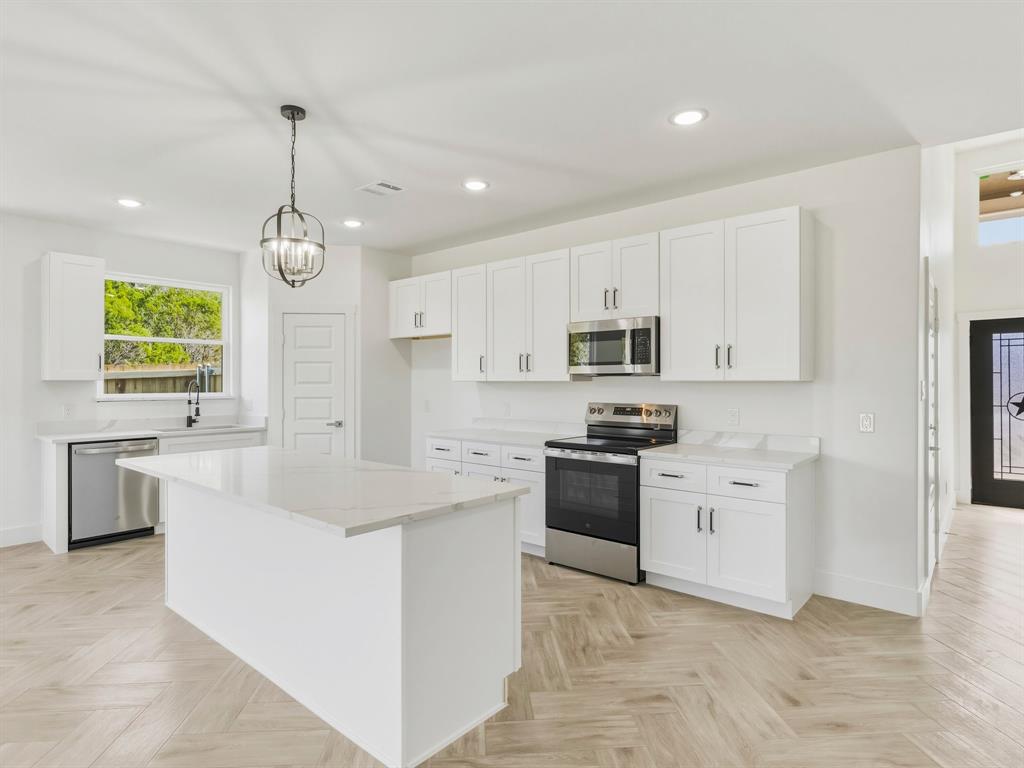 1412 Ridgeview Circle Granbury, TX 76048 - Photo 4 of 20 a large white kitchen with a stove a sink a refrigerator and a stove top oven