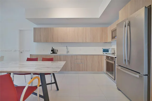 a kitchen with stainless steel appliances a refrigerator sink and cabinets