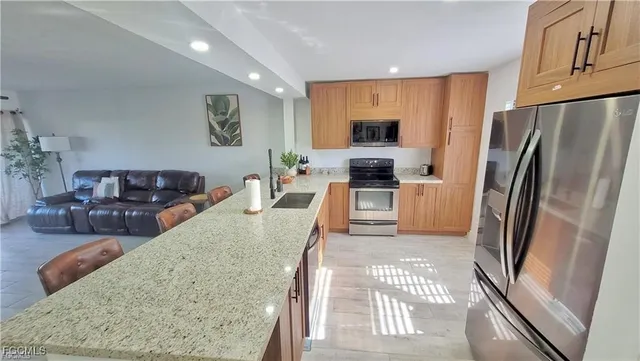 a kitchen with stainless steel appliances granite countertop a refrigerator sink and stove