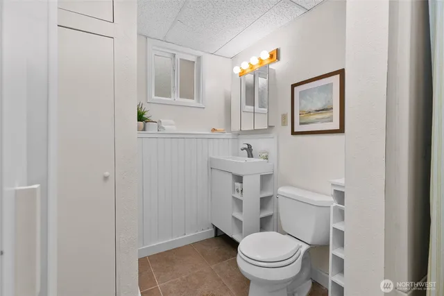 a bathroom with a toilet a sink and a mirror